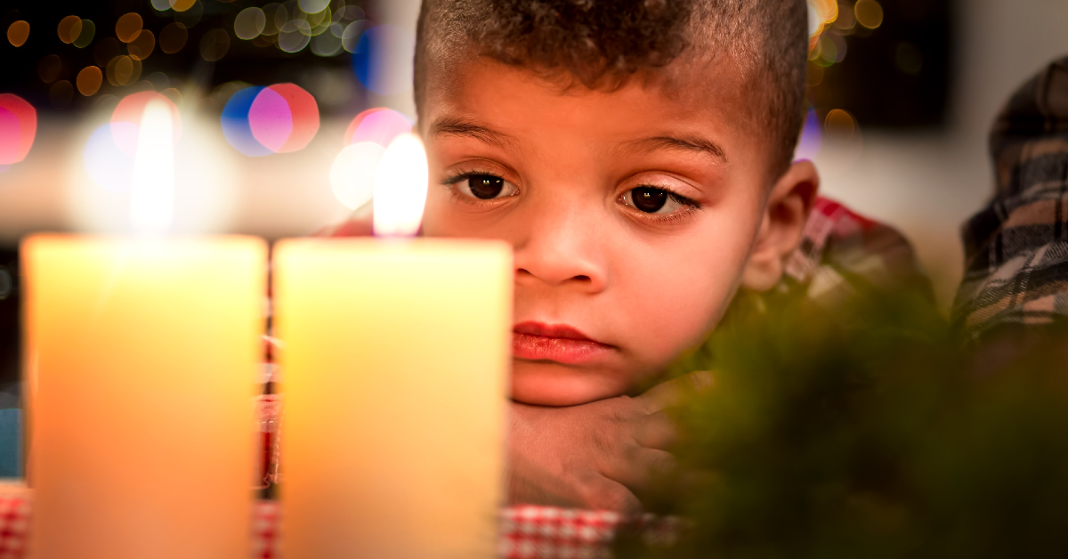 Young boy looks at holiday candles