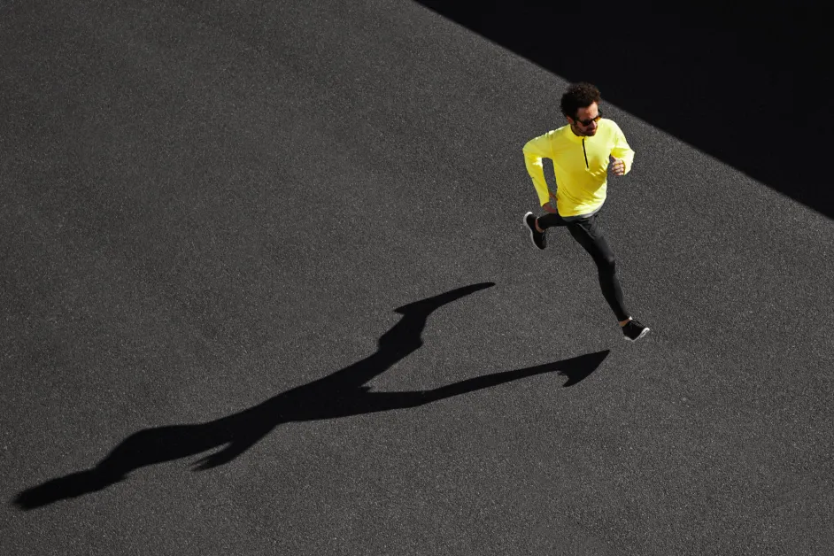 man running in a yellow jacket