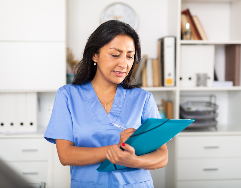 Woman in nurse uniform holding a folder and writing notes