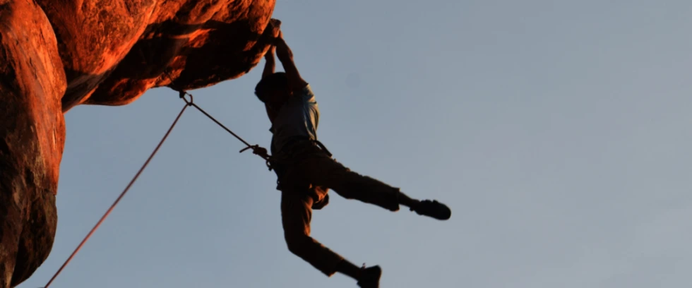 Rock climber hanging off a clip