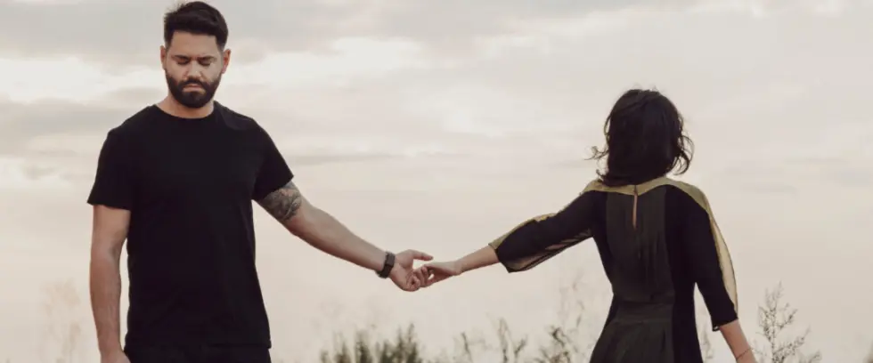 Couple holding hands outdoors in a field