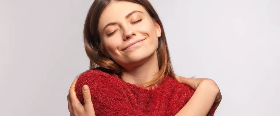 Woman hugging herself and smiling