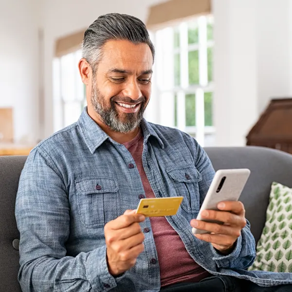 Man with an Insurance Card In his Hand on Phone with Therapist